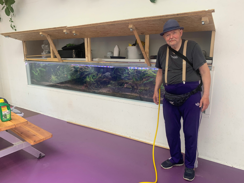 gammel mand ved akvarie